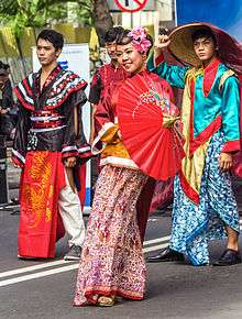 Students in Chinese fusion clothing holding a parasol and smiling