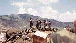 A group of officers in field gear standing in the middle of a base.