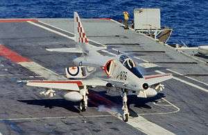 Colour photograph of a grey military aircraft on the deck of an aircraft carrier