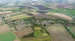 View of village taken from the air showing road on left and river on right