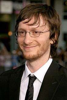 A profile picture of a blonde man who is smilling. He wears glasses and tuxedo.