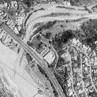 A dry wash curves from the upper right through a sandy basin down onto a beach on the left and its subsequent confluence with a larger body of water