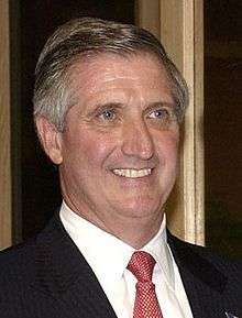 Smiling man wearing a suit and a red tie