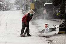 A man in a red shirt, sweeping