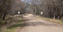 A dirt road with a bridge