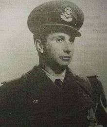 A young man dressed in a military uniform, including coat and hat with insignia.