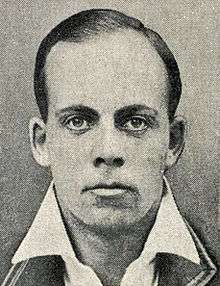 A head shot of a man in a blazer.