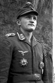 A man wearing a military uniform, field cap and various military decorations.