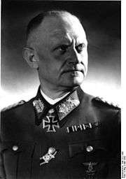 A black-and-white photograph of a man wearing a military uniform and a neck order in shape of an Iron Cross.