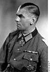 Black-and-white portrait of a man in semi profile wearing a military uniform with an Iron Cross displayed at his neck.