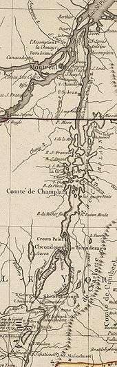 The map is oriented with north to the top. The lower section of the map shows Saratoga, New York and Fort Edward, on the Hudson River.  There are red markers depicting the position of John Burgoyne's army near Saratoga at the time of its surrender in 1777. A line of mountains is shown to the right of the Hudson, extending northward but eventually bending off the map to the east.  North of Fort Edward are Fort George, at the southern end of Lake George, and Skenesborough, near the southern end of Lake Champlain.  About one third of the way up the map,  Lake George joins with Champlain, and Fort Ticonderoga is shown at the northwest side of the junction.  Lake Champlain extends to the north and is dotted with islands.  There is a red line marking the boundary between New York and Quebec, and the upper third of the map shows the Richelieu River extending north to meet the Saint Lawrence River at Sorel, with Montreal southwest of that point.