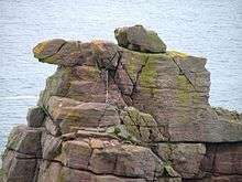 On a rocky outcrop, the top of the stack, is a tangle of ropes and carabiners.