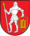 A coat of arms depicting a man in full body armour holding a white spear in his right hand and a red-and-yellow shield in his left hand