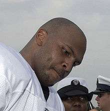 Head shot of black man with shaved head looking down pensively