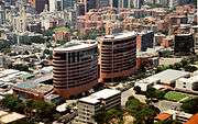 Two taller, oval buildings surrounded by other tall buildings