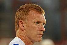 The head of a red-haired gentleman in his 40s. He is wearing a blue and white shirt.