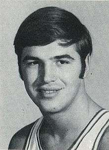 A basketball player wearing a jersey and smiling for a photo.