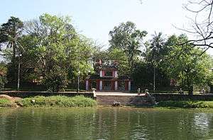 A temple with red tiles, pillars holding up the two levels