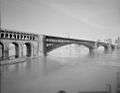 monochrome brick and steel bridge, spanning a river