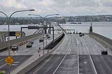 A long floating bridge crossing a lake in a suburban area