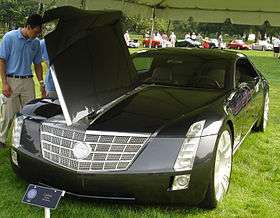 Man looking at Cadillac Sixteen with open hood.