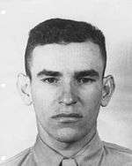 A head and shoulders portrait of a young, cleanshaven man with dark hair.