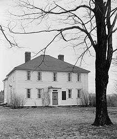 Image of a two-story frame house with hipped roof and two chimneys