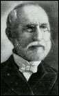 Head shot of balding gentleman with neatly trimmed white hair, moustache and beard, wearing glasses