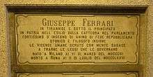 A marble gravestone on the wall of a crypt