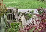 A detail of the patio stones showing some used for decoration in a planter, forming "V" shapes amid ornamental plants.