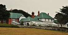 Large, rambling house with greenhouse and stone wall