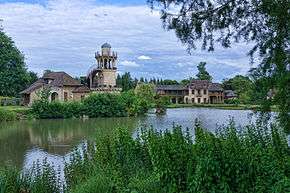 Le Hameau de la Reine, avec, à gauche, la tour de Marlborough, au centre l’étang et au fond à droite la Maison de la Reine