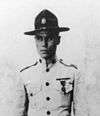 Top half of man in 1920s tropical U.S. Marine uniform with flat-brimmed campaign hat.