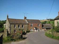 Two-storey stone houses with a road in front.