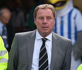 The upper body of a sandy haired man with a face with relaxed muscle tone. He is looking into the distance to his left. He is wearing a grey jacket and dark, striped tie.