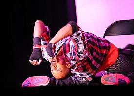 Male hip-hop dancer performing on stage inside a theater at Fort Belvoir army installation.