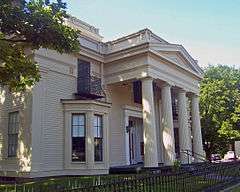 Front view of Todd House, with coluumns and iron fence