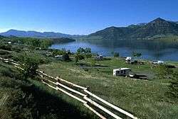 View of a deep blue lake surrounded by low mountains