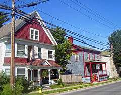 A red and white house next to a smaller one in blue with red trim