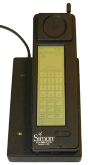 Photograph of the Simon Personal Communicator shown in its charging base