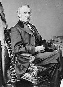 Seated man in suit posing for picture.