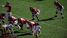 American football players in position prior to a snap.