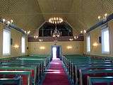 Inside a wooden church, facing away from the altar, towards the entrance.