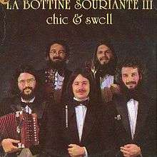 Photograph of La Bottine Souriante, posing with instruments