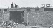 A fire-damaged building with a pile of ruined film cans