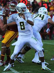 A picture of Marcus Mariota while holding a football during a game.