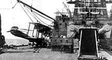 two biplanes on the decks, one on the side deck and one centered on an upper deck behind the main turret.