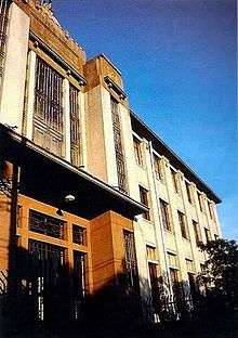 Front of three-story building against a blue sky