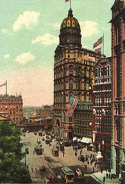 Drawing of 20-story building with a tan exterior; the roof is topped with a large, gold dome and a flagpole.