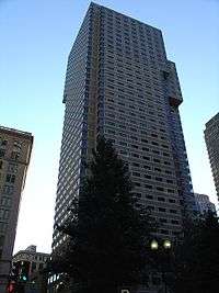 Ground-level view of a 40-story skyscraper with a tan facade; minor setbacks are visible around the tower's 30th floor